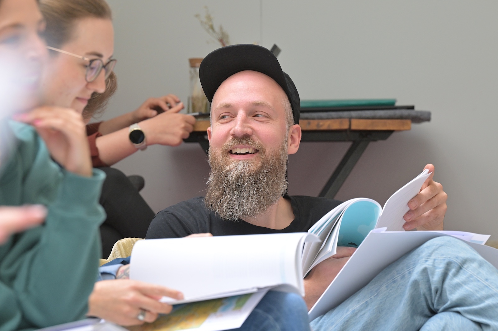 "Freundlich interessiert schauender Teilnehmer im Workshop nach eigenem
                Aha-Moment"